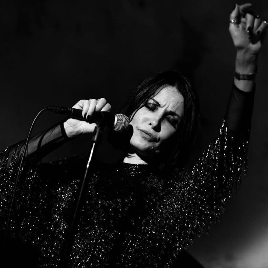 Woman with arm in air holding mike
