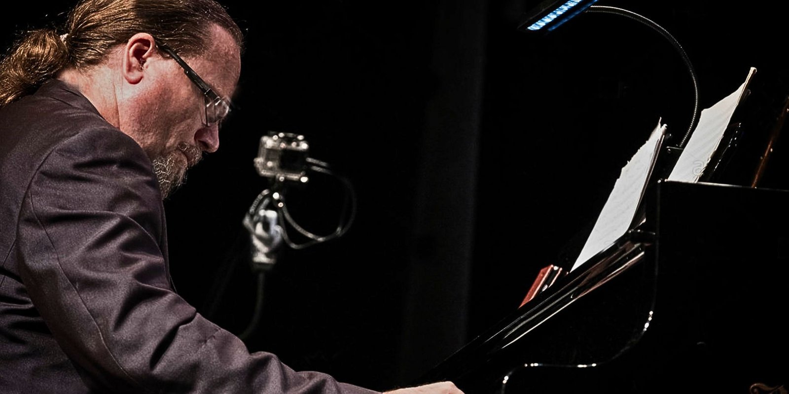 Craig Milverton sitting at piano in profile