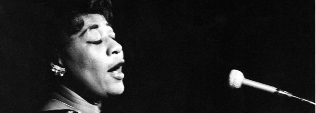 Black woman in profile at piano singing