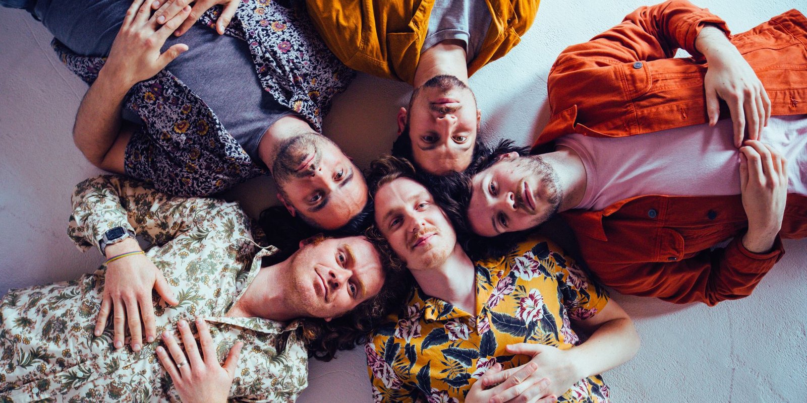 Five men laying on their backs looking into camera - Mamas Gun